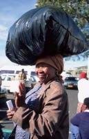 Stock photo of load balancing woman at a market place in South Africa