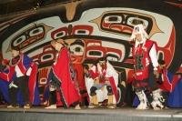 A Colourful Display of American Native Dress and Dance backdropped by the symbols of their People in Juneau Alaska.