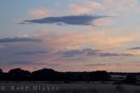 Clouds of various hues float slowly through the sky at sunset near Huesca and the Pyrenees Mountain Range in Aragon, Spain in Europe.