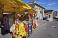 Merchandise of strikingly beautiful colored merchandise is sold at the market outside Les Arenes in Arles, France.