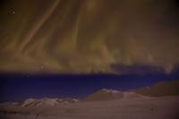 A Curtain of Northern Lights almost touch the Yukon Mountains.