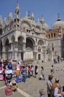 Tourists in the Piazza San Marco admire the Basilica di San Marco in Venice, Italy.