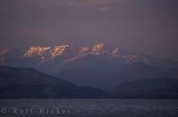 A vibrant pink sunset tints the landscape surrounding the BC Coast Mountains of Canada.