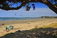 A popular weekend retreat for Aucklanders, the village of Orewa along the Hibiscus Coast, has a busy beach scene with kitesurfers, swimmers, land sailers, and sun bathers.