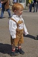 A young boy is dressed in traditional Bavarian lederhosen during the Maibaumfest in Putzbrunn, Germany.