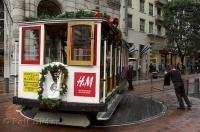 A decorated cable car is turned around on a turntable in downtown San Francisco, California, USA.