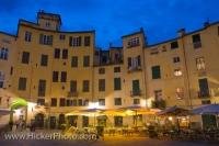 A quaint collection of cafes and restaurants line the outside of the old Roman Amphitheatre in the Piazzo Anfiteatro at dusk. The Piazza, which was originally built in 180 BC is one of the most famous sites in the city of Lucca in the Tuscany, Italy.