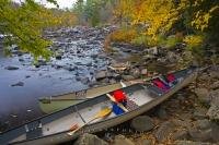 A couple of canoes hauled out on the bank of the Oxtongue River near the Ragged Falls in the Oxtongue River-Ragged Falls Provincial Park in Ontario.
