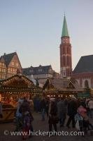 Bundled in their winter clothing, people roam between the stalls at the Christmas Markets in the Romerplatz in Frankfurt, Hessen in Germany, Europe.