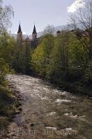 The church spires can be seen above the trees along the riverbanks in the town of Bruneck in the South Tyrol in Italy, Europe.