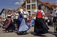 Dancers in traditional cloth performing on the road at the Maibaumfest in Putzbrunn, Germany.