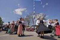 A group of people participate in dancing at the Maibaumfest in Putzbrunn, Germany.