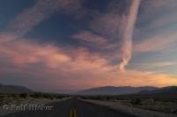 The sun sets over a road in Death Valley National Park, California, USA.