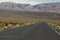 A long stretch of road leading into Death Valley in California, USA.