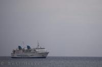 Under cloudy skies the ferry prepares to approach the port of Denia in Spain to unload and load passengers.