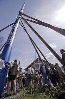 The German people use poles to raise the Maibaum in this European village near Munich, Germany.