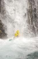 A kayaker takes a nose dive while waterfall running, an extreme water sport.