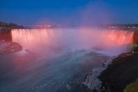 The water and the mist of the world-famous Horseshoe Falls is lit up in a variety of pinks and blues as the day draws to a close and the nightly Falls Illumination show takes place. This set of falls is located on the Canadian side of the Niagara River.