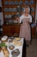 A costumed interpreter explains how family meals were done during the historic colonial days of the 18th century at the Fortress of Louisbourg in Nova Scotia, Canada.