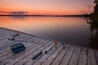 A beautiful sunset over a wooden wharf and fishing tackle and equipment at Lake Audy in Riding Mountain National Park, Manitoba Canada.