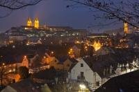 An aerial picture over the rooftops of homes and of the Freisinger Dom at dusk as the city of Freising is illuminated by street lighting on a cool winter evening.