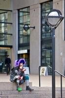 A purple hat and one boot painted green, this funny character is wearing a unique costume and is probably one of a kind.