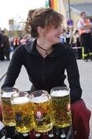 A traditionally dressed woman distributes steins of German Beers during the Maibaumfest in Putzbrunn, Germany.