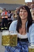 A traditionally dressed woman serves up German Helles Beer during the Maibaumfest in Putzbrunn, Germany.