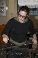 A picture of a woman glassblowing at the Lincoln City Glass Center in Oregon, USA.