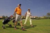 After two seniors were swinging their clubs, there is more exercise when pulling the golf cart at the eighteen hole course, the Oliva Nova Golf Course in Valencia, Spain in Europe.