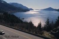 The sun sets over Howe Sound and the Sea to Sky Highway 99 in British Columbia, Canada.