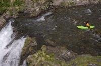 A kayaker prepares for his descent over the Sauth deth Pish on a kayaking adventure in the Val d'Aran in the Pyrenees in Catalonia, Spain.