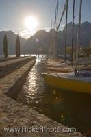 The sunlight shines off the sailboats tied up along the Lake Garda waterfront in the town of Torbole in the Province of Trento, Italy in Europe.