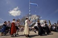 The decorated Maibaum flys the flag of Bavaria as dancers perform in the town of Putzbrunn, Germany.