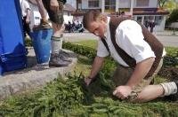 A volunteer at the Maibaumfest prepares the greenery for the wreath at the base of the Maibaum in Putzbrunn, Germany.