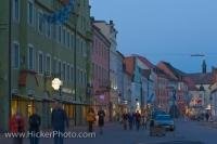 Even as dusk falls, the shops along the main street, Untere Haupstrasse, in Freising, Bavaria in Germany still attract the people strolling by.