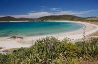 Maitai Beach on the Karikari Peninsula on the North Island of New Zealand curves around the water's edge creating the ideal location for visitors.