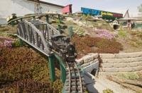 A train passes over a bridge at the Big Sky Garden Railway a miniature model set in Nanton, Alberta, Canada.