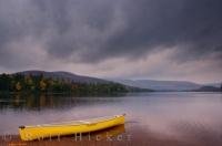 A canoe rests upon the shores of Monroe Lake in Mont Tremblant Provincial Park in Quebec, Canada during the Autumn season.