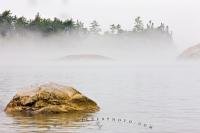 In this picture, the fog blurs the line where water meets land and the lake a mystic feel on a spring morning to Sinclair Cove, Lake Superior in Lake Superior Provincial Park in Ontario, Canada.