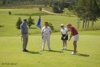 A foursome on vacation playing a round of golf at St. Andrews Na Creige Golf Course in Newfoundland, Canada.