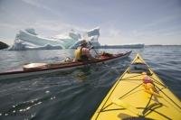 Stock Photo of sea kayaking around an large iceberg