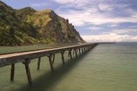 A wharf struts out into the waters of Tokomaru Bay in the East Cape of New Zealand.