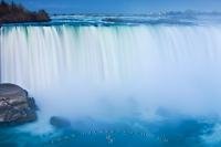 The Horseshoe Falls form part of the Niagara Falls waterfall seen here plunging over the Niagara Escarpment at twilight in early spring, Province of Ontario, Canada.