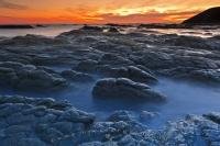 The Kaikoura Peninsula features a dramatic rocky landscape which fringes the waters of the Pacific Ocean in Canterbury, New Zealand. A beautiful time to visit this area of the peninsula is at sunset.