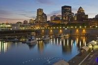 The night lights along the Old Port and downtown Montreal, Quebec begin to sparkle as the enlightened sky at sunset starts to darken.