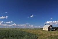 An old stone church which is surrounded by an open field with a cemetery at the rear in Mantitoba, Canada.