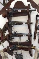 On a wooden rack hanging on the wall in a shop in the Karlstein Village in the Czech Republic, a pistol display intrigues tourists.