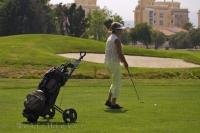 A lady at the Oliva Nova Golf Course in Valencia, Spain pulls out her pitching wedge for her next shot onto the green.