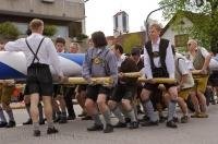 The team of men while dressed in traditional Bavarian lederhosen lift the Maibaum in Putzbrunn, Germany.